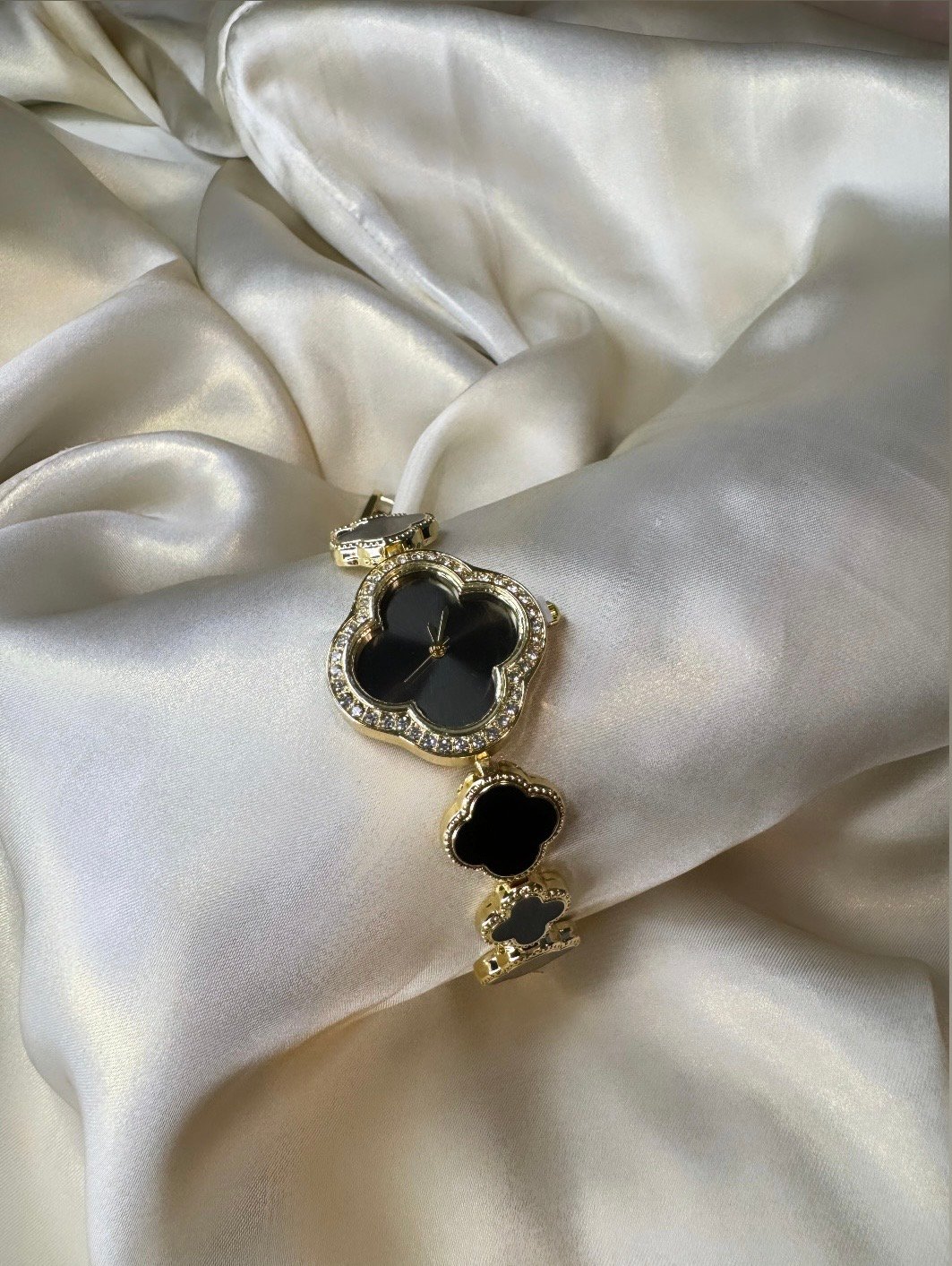 Black clover watch Black clover-shaped watch with gold-tone finish and adjustable bracelet.